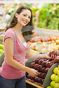 Woman choosing apples at produce counter