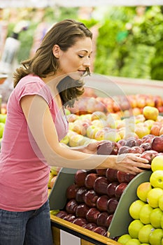 Woman choosing apples in produce department
