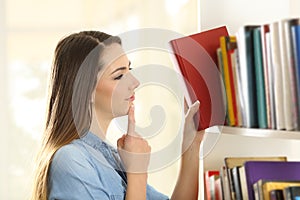 Woman choosing a book from shelving photo