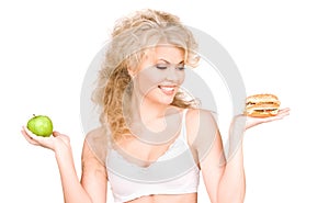 Woman choosing between burger and apple