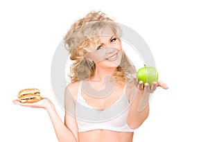 Woman choosing between burger and apple