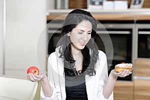 Woman choosing cake or fruit