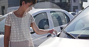 Woman choosing car for buying in dealership really desiring