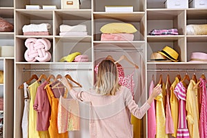 Woman choosing clothes from large