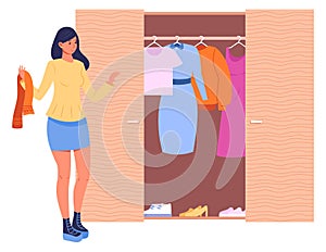 Woman choosing clothes from wardrobe closet. Home storage
