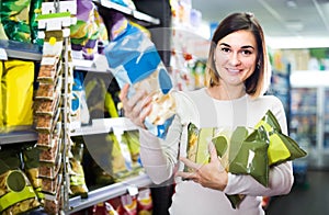 Woman choosing delicious snacks in supermarket