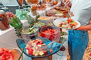 Woman choosing food in open buffet at breakfast