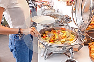 Woman choosing food in open buffet