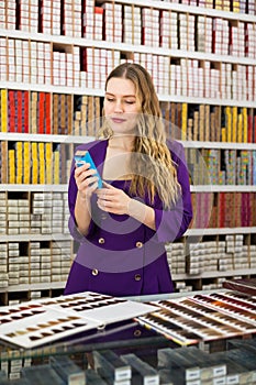 Woman choosing hair dye at cosmetics store