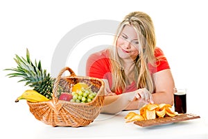 Woman choosing junk food over healthy fruit
