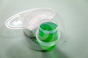 Woman choosing from laundry detergent between of powder and liquid gel for washing clothes