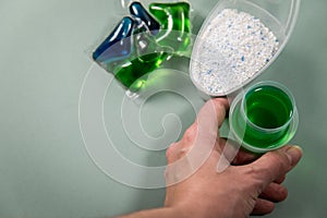 Woman choosing from laundry detergent variety of powder, liquid gel and pod for washing clothes