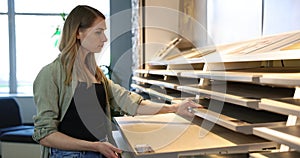 Woman choosing materials from samples for her new home at interior design store