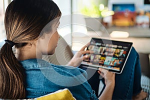 Woman Choosing Movie For Streaming On Tablet Computer