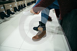 Woman choosing new boots in the shop