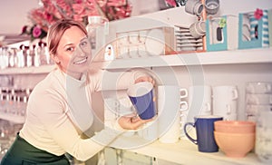 Woman choosing new crockery in dinnerware store