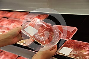 Woman choosing packed chicken meat