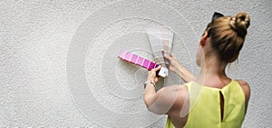 Woman choosing paint color from swatch for house stucco exterior facade