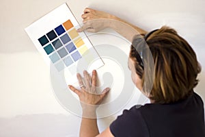 Woman choosing paint color for wall
