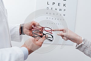 Woman choosing a pair of glasses photo