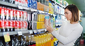 Woman choosing refreshing beverages in supermarket