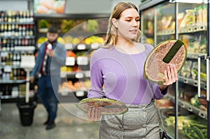 Woman choosing semi-finished frozen pizza