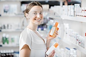 Woman choosing sunscreen lotion at the pharmacy photo
