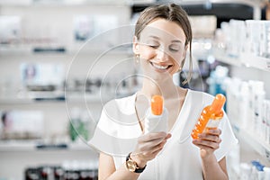 Woman choosing sunscreen lotion at the pharmacy photo