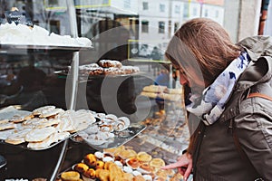 woman choosing sweet cakes at street cafe in Portugal