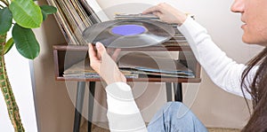 Woman choosing vinyl records at home for listening