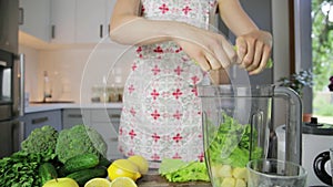 Woman chopping green vegetables for detox smoothie at home. Healthy eating, vegetarian food, dieting