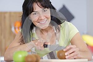 woman chopping tomato on chopping board