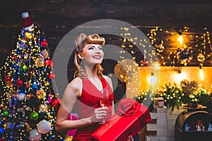 Woman in Christmas dress near the Christmas tree. Christmas preparation - luxury girl celebrating new year. Merry