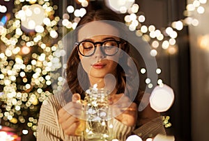 Woman with christmas garland lights in glass mug