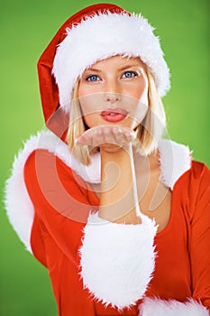 Woman, Christmas and kiss in studio portrait for holiday celebration, festive greeting or winter vacation. Female person