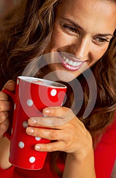 Woman in christmas red dress having cup of hot bever