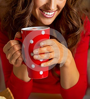 Woman in christmas red dress having cup of hot bever