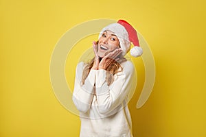 Woman christmas Sants Hat sweater yellow studio background