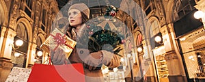 woman with Christmas tree and gift in Galleria Vittorio Emanuele