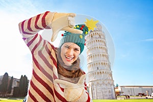 Woman in Christmas tree hat framing near Leaning Tour of Pisa