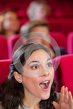 Woman in cinema audience with expression delight