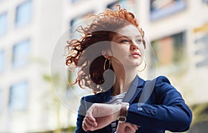 Woman in city, checking time and watch on wrist on morning commute to work or appointment. Street, schedule and