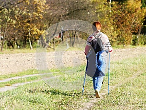 A woman in city clothes stroll through the summer`s grass in the rays of sunlight. Healthy lifestyle. Sport`s event. A personal ex