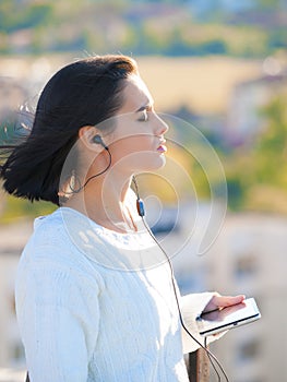 Woman, city and earphones with tablet, podcast or music for listening or relaxing while thinking. Worker, technology and