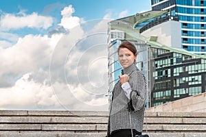 Woman on cityscape background looking straight into the camera. Successful woman concept