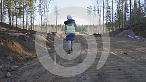 Woman civil engineer at checking levels of road