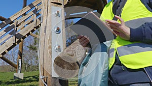 Woman civil inspector examining wooden tower