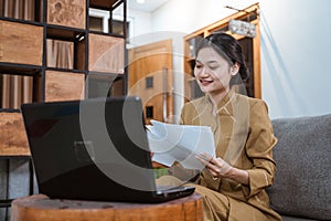 woman civil servant working from home using laptop computer and worksheets sitting