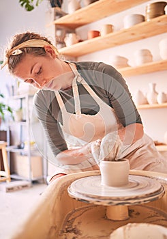 Woman, clay artist and pottery wheel for sculpture design, creative manufacturing and expert focus in studio workshop