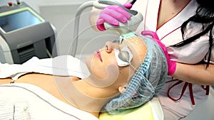 Woman with clay facial mask in beauty spa.
